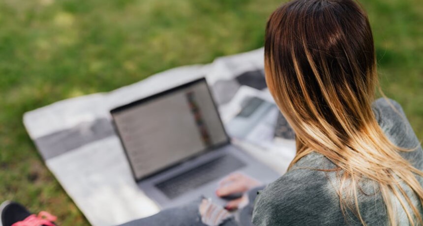 Vrouw in het park achter haar laptop