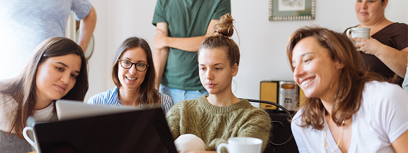 Een groep collega's die gezamelijk kijken naar een scherm